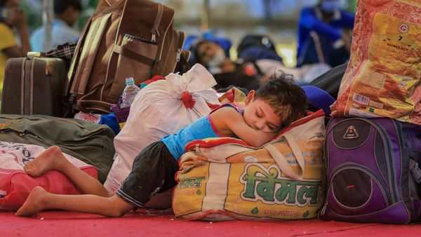 জয়পুরের কোয়ারেন্টাইন সেন্টার থেকে বাড়ি ফেরার জন্য বাসের অপেক্ষায় পরিযায়ী শ্রমিকরা। ক্লান্তিতে ঘুমিয়ে পড়ল পরিবারের শিশুটি। ছবি: পিটিআই। (PTI) জয়পুরের কোয়ারেন্টাইন সেন্টার থেকে বাড়ি ফেরার জন্য বাসের অপেক্ষায় পরিযায়ী শ্রমিকরা। ক্লান্তিতে ঘুমিয়ে পড়ল পরিবারের শিশুটি। ছবি: পিটিআই। (PTI)