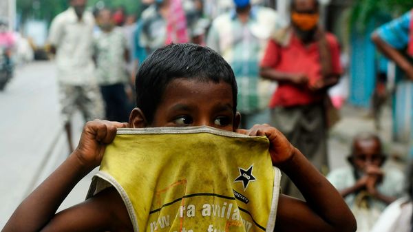 A child gestures as he waits in a queue to collect free food on the side of a road during a complete lockdown announced by the state government, in Kolkata on July 25, 2020. - Flight operations are suspended on July 25 and 29 amid a total lockdown in place across the state as a preventive measure against the COVID-19 coronavirus. (Photo by Dibyangshu SARKAR / AFP) (AFP) A child gestures as he waits in a queue to collect free food on the side of a road during a complete lockdown announced by the state government, in Kolkata on July 25, 2020. - Flight operations are suspended on July 25 and 29 amid a total lockdown in place across the state as a preventive measure against the COVID-19 coronavirus. (Photo by Dibyangshu SARKAR / AFP) (AFP)