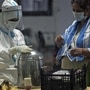 A health worker wearing PPE kit gives tea to a covid patient at CWG COVID Care Centre, in New Delhi on Thursday. (ANI Photo)