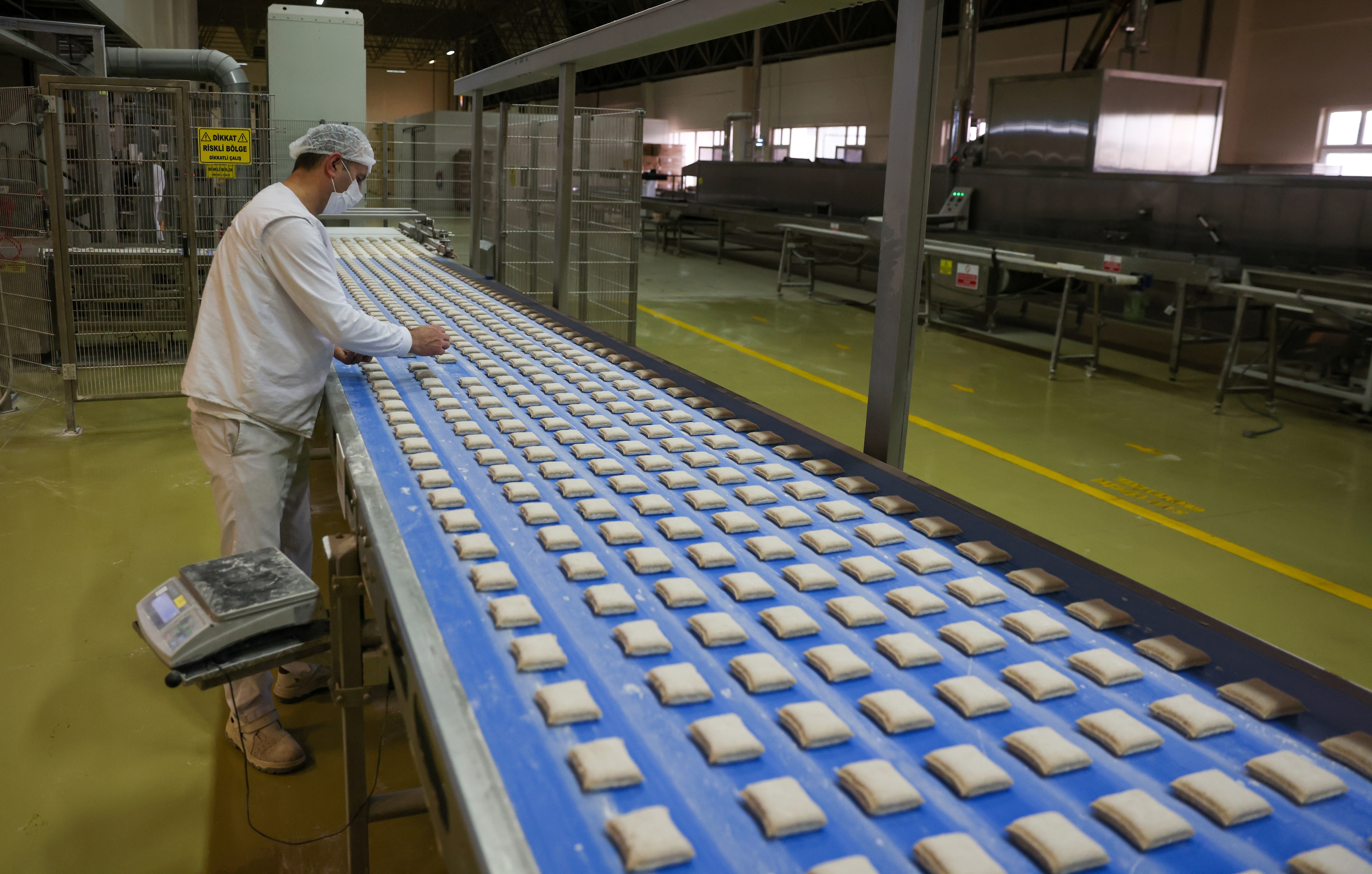 কিন্তু দাম বাড়ানো হল কেন? রাজ্যের বেকারি সংগঠনের দাবি, ময়দা, তেল, চিনি-সহ কাঁচামালের দাম ক্রমশ বেড়েছে। শ্রমিকদের বেতনও বাড়ানো হয়েছে। সেজন্যই বাধ্য হয়ে পাউরুটির দাম বাড়াতে হচ্ছে। (ছবিটি প্রতীকী, সৌজন্যে রয়টার্স)