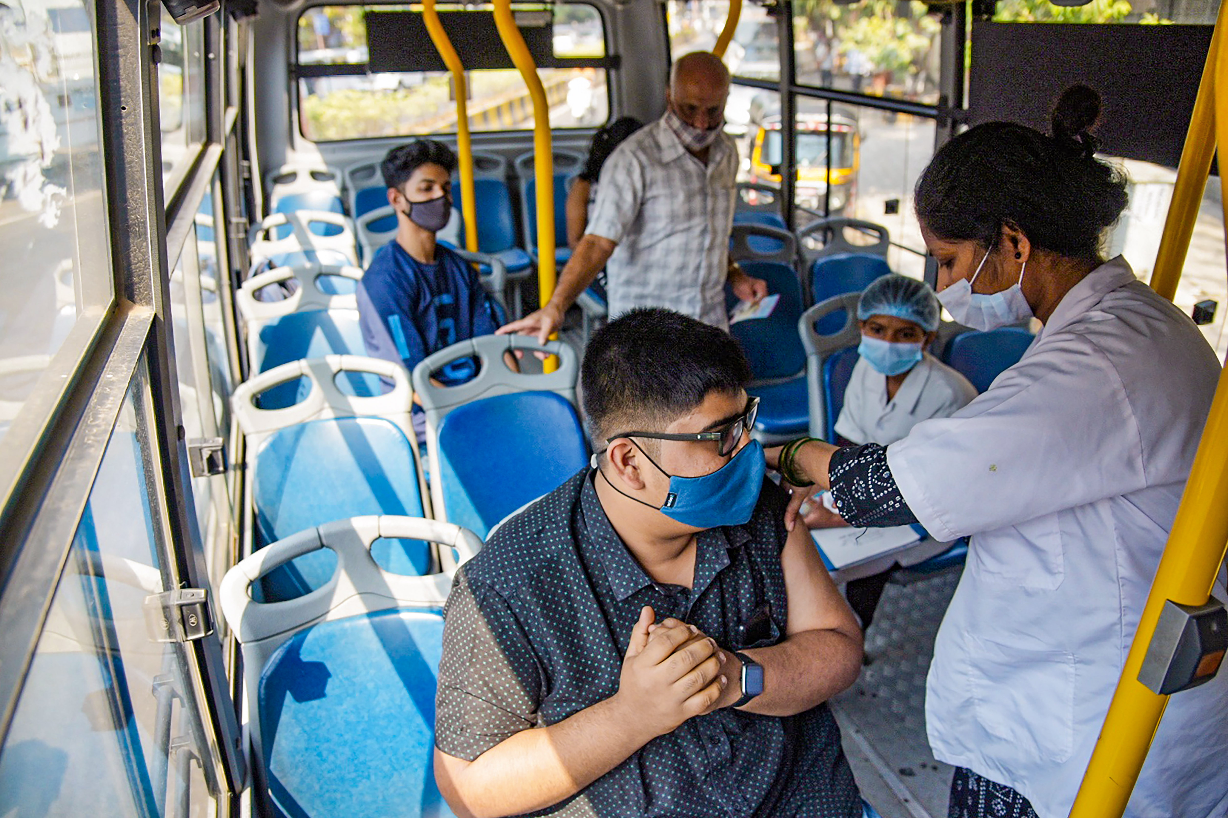 Navi Mumbai: An NMMC Health Department employee administers COVID-19 vaccine dose to a passenger inside a NMMT bus, at Vashi, in Navi Mumbai, Tuesday, Feb 8, 2022. (PTI Photo)  (PTI02_08_2022_000196B) (PTI)