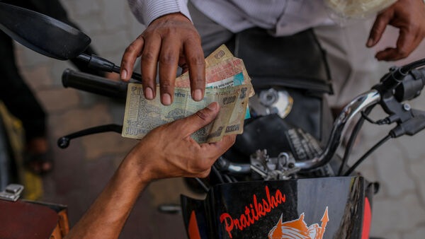 Indian rupees exchange hands for fuel for a motorbike at a Bharat Petroleum Corp. gas station in Hyderabad, India, on Wednesday, March 23, 2022. India�s urban consumption is driving recovery from late pandemic wave but has further intensified the divergence between cities and the hinterland, according to a report by�Citigroup Inc�released last week. Photographer: Dhiraj Singh/Bloomberg (Bloomberg)