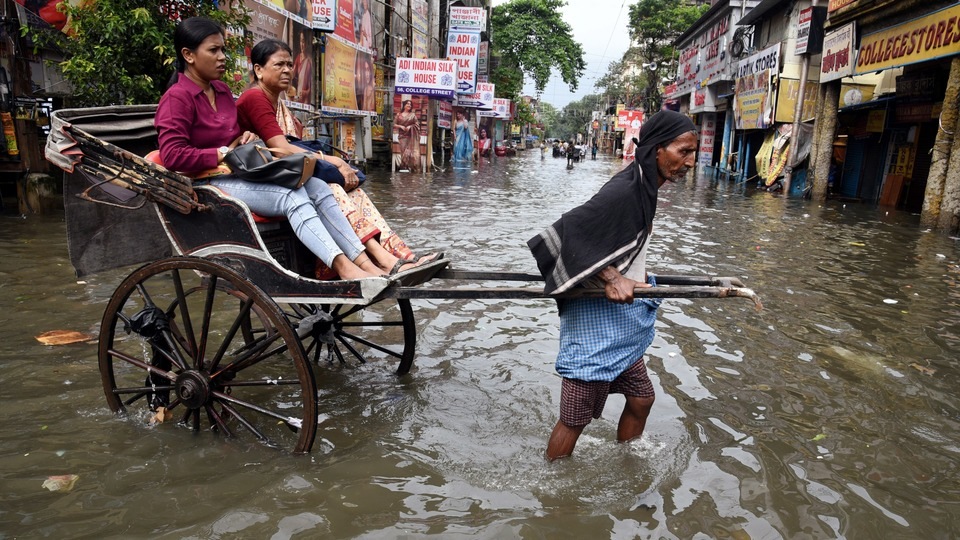 কলকাতার রাস্তায় জলাবদ্ধতার পর হাঁটু পর্যন্ত জলে হেঁটে যাচ্ছেন একজন হ্যান্ড রিকশাওয়ালা।(Debajyoti Chakraborty/ANI)
