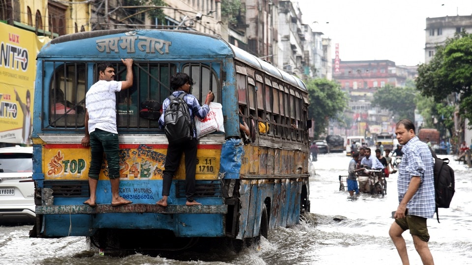 মঙ্গলবার কলকাতায় ভারী বৃষ্টির ফলে জলাবদ্ধ রাস্তা দিয়ে হেঁটে যাচ্ছেন যাত্রীরা।(Debajyoti Chakraborty/ANI)