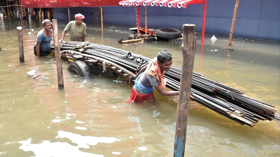 কলকাতায় ভারী বৃষ্টির ফলে জলাবদ্ধ রাস্তা দিয়ে একটি ভারী গাড়ি টেনে নিয়ে যাচ্ছেন যাত্রীরা।(Saikat Paul/ANI)