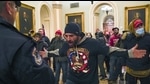 Trump supporters gesture to US Capitol Police in the hallway outside of the Senate chamber after breaching the halls of the Capitol in Washington, January 6, 2021 (AP) Trump supporters gesture to US Capitol Police in the hallway outside of the Senate chamber after breaching the halls of the Capitol in Washington, January 6, 2021 (AP)