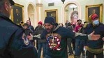 Trump supporters gesture to US Capitol Police in the hallway outside of the Senate chamber after breaching the halls of the Capitol in Washington.(AP) Trump supporters gesture to US Capitol Police in the hallway outside of the Senate chamber after breaching the halls of the Capitol in Washington.(AP)