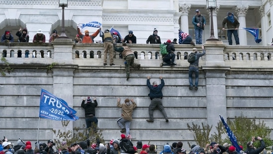 Supporters of President Donald Trump climb the west wall of the the US Capitol in Washington on January 6,(Jose Luis Magana / AP)
