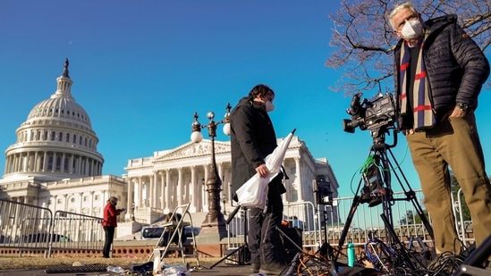 Members of the news media survey damaged equipment outside the US Capitol a day after the violence on January 7. The US President has been permanently suspended from Twitter due to the "risk of further incitement of violence", the social media giant has announced on January 9.(Erin Scott/REUTERS)