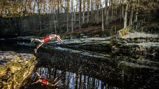Les Peebles dives into the River Ribble near Stainforth, England on January 6, in an effort to raise money for the Crisis homeless charity. Peebles has pledged to swim in open water every day during January to raise money for the Crisis charity that offers year-round education, employment, housing and well-being services for homeless people.(Danny Lawson / PA via AP)