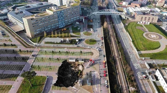 A aerial view shows a sinkhole in the Ospedale del Mare hospital car park, where people come for Covid-19 testing, on the outskirts of the city of Naples, after the ground collapsed early on January 8, destroying some vehicles.(Ciro Fusco / ANSA / AFP)