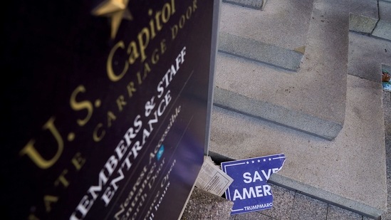 Scraps of a demonstrator's poster lays below a Congressional members and staff entrance sign at the Senate Carriage Entrance on January 7. The rampage that left five people dead and a country on edge as Donald Trump's presidency comes to an end.(Erin Scott / REUTERS)