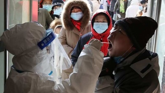 A medical worker in protective suit collects a swab from a resident during a mass nucleic acid testing following a recent coronavirus disease (Covid-19) outbreak in Shijiazhuang, Hebei province, China. (REUTERS)