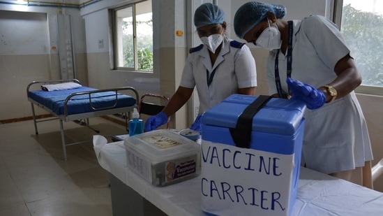 Health workers examine a vaccine carrier at Thane Municipal Corporation’s Roja Gardenia Health Centre in Thane on January 8. The Directorate General of Civil Aviation (DGCA) also issued guidelines to all aircraft operators who plan to transport Covid-19 vaccines packed in dry ice to various parts of the country.(Praful Gangurde / HT Photo)
