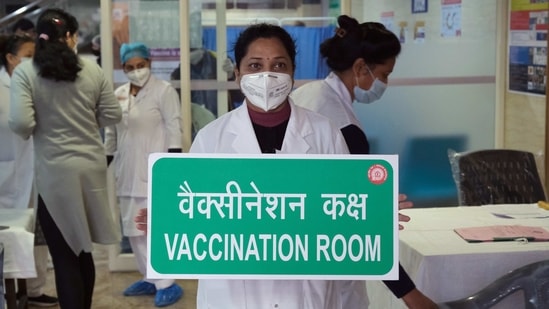 A health worker holds a sign reading “Vaccination Room” during the dry run of Covid-19 vaccination at Northern Railway Central Hospital in New Delhi on January 8. The dry run was also aimed at familiarising the state, district, block and hospital-level officers on all aspects of Covid-19 vaccine roll-out.(T Narayan / Bloomberg)