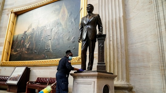 A worker cleans a statue of former President Ronald Reagan inside the Rotunda of the US Capitol a day after the storming. As officials sifted through the aftermath of the mob’s siege, there was growing discussion of impeaching him a second time or invoking the 25th Amendment to oust him from the Oval Office.(Erin Scott / REUTERS)