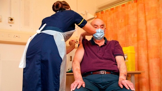 82-year-old Brian Pinker receives the Oxford University/AstraZeneca COVID-19 vaccine from nurse Sam Foster at the Churchill Hospital in Oxford, southwest England on January 4.(Steve Parsons / POOL / AFP)