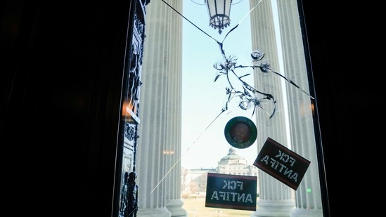 Bullet holes and stickers are seen on an entrance to the US Capitol on January 7. Capitol Police Chief Steven Sund praised his officers, saying they "responded valiantly" when demonstrators attacked them with "metal pipes, discharged chemical irritants and took up other weapons" and also faced two pipe bombs. Sund later said he would resign effective January 16, according to a letter cited by news outlets.(Erin Scott/REUTERS)