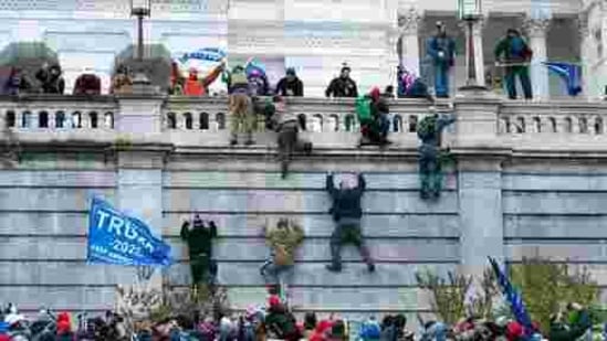 Supporters of President Donald Trump climb the west wall of the the US Capitol in Washington.(AP)