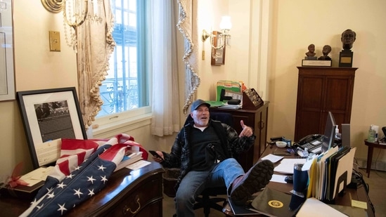 A supporter of US President Donald Trump sits inside the office of US Speaker of the House Nancy Pelosi as he protest inside the US Capitol in Washington,(AFP)