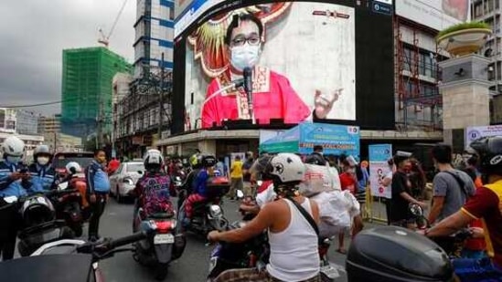 A Catholic priest is seen on an electronic screen as he officiates a mass in Quiapo church in downtown Manila, Philippines on the eve of the Black Nazarene feast day, Friday Jan. 8, 2021. (AP)