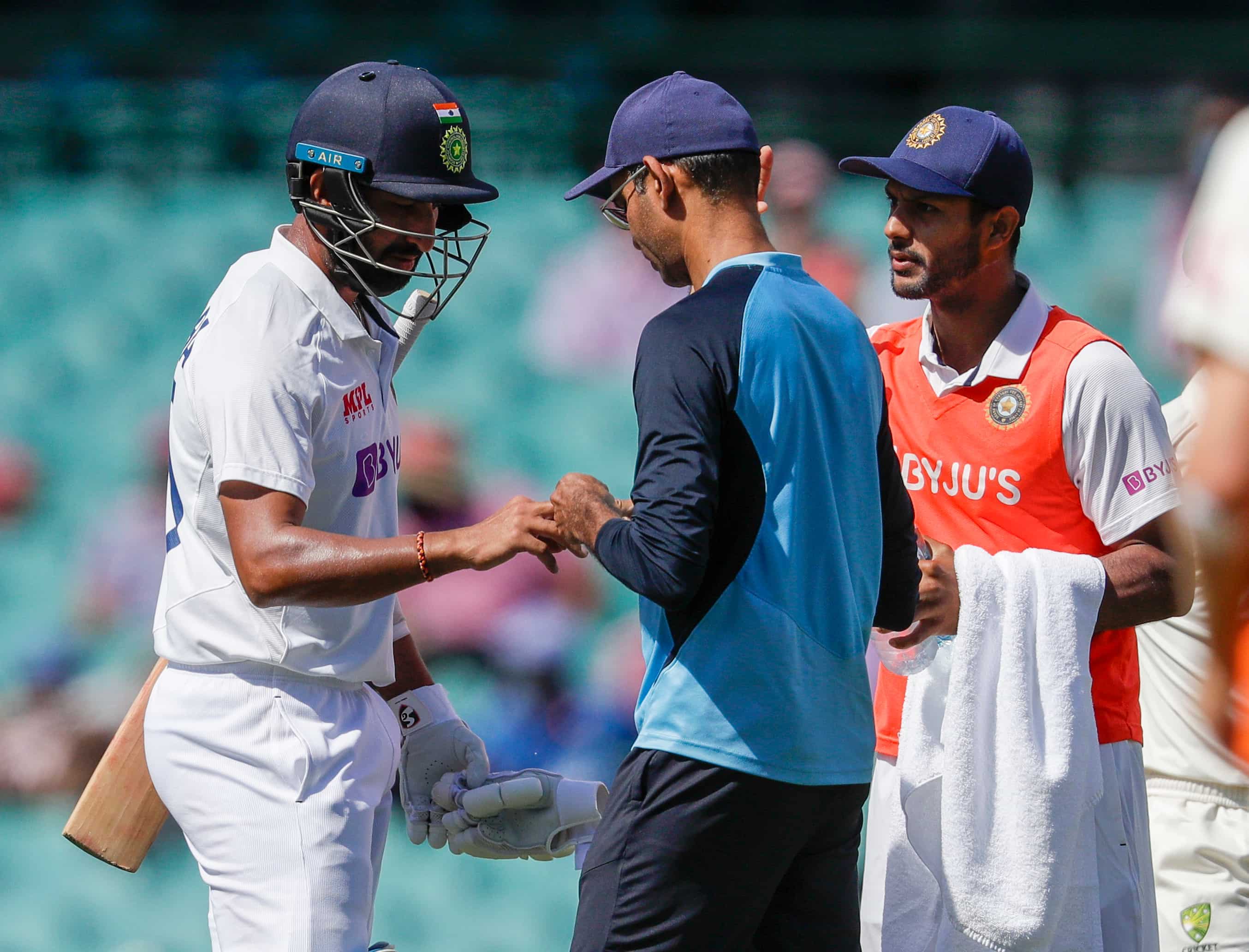 India's Cheteshwar Pujara, left, has treatment to a finger injury during play on day three of the third cricket test between India and Australia at the Sydney Cricket Ground, Sydney, Australia, Saturday, Jan. 9, 2021. India's Cheteshwar Pujara, left, has treatment to a finger injury during play on day three of the third cricket test between India and Australia at the Sydney Cricket Ground, Sydney, Australia, Saturday, Jan. 9, 2021.