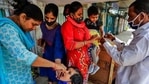 A health worker administers polio vaccine to a child as another marks a child on her finger.(AP) A health worker administers polio vaccine to a child as another marks a child on her finger.(AP)