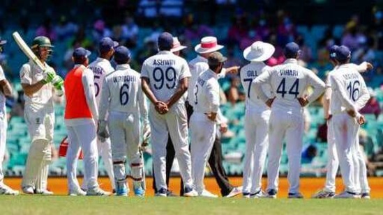 Australia's Tim Paine, left, waits as Indian players talk with the umpires over an issue with the crowd during play on day four of the third cricket test between India and Australia at the Sydney Cricket Ground(AP) Australia's Tim Paine, left, waits as Indian players talk with the umpires over an issue with the crowd during play on day four of the third cricket test between India and Australia at the Sydney Cricket Ground(AP)