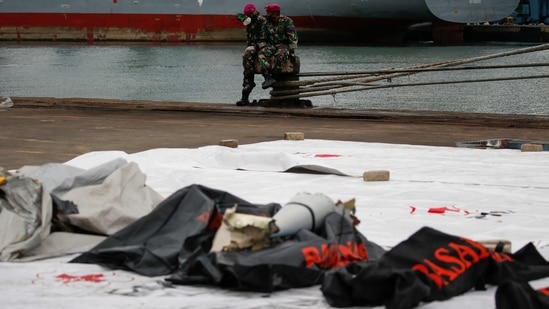 Indonesian soldiers rest as debris of Sriwijaya Air flight SJ 182 is retrieved at Tanjung Priok port in Jakarta on January 10. There were no immediate clues on what may have caused the jet's sudden descent. Safety experts stress that most air accidents are caused by a cocktail of factors that can take months to establish.(WIlly Kurniawan / REUTERS)