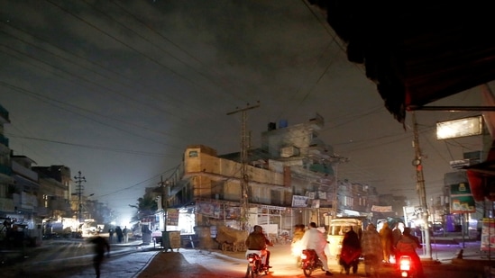 Rawalpindi : People are silhouetted on vehicles headlights on a dark street during widespread power outages in Rawalpindi, Pakistan, Sunday, Jan. 10, 2021. AP/PTI(AP01_10_2021_000019B) (AP) Rawalpindi : People are silhouetted on vehicles headlights on a dark street during widespread power outages in Rawalpindi, Pakistan, Sunday, Jan. 10, 2021. AP/PTI(AP01_10_2021_000019B) (AP)