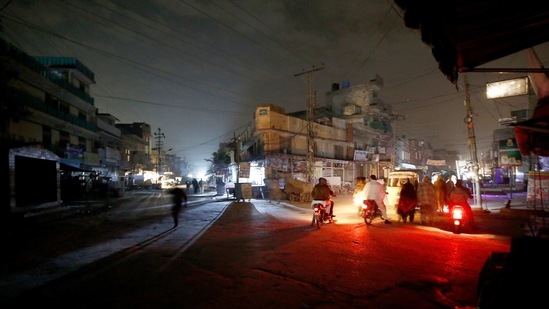 Rawalpindi : People are silhouetted on vehicles headlights on a dark street during widespread power outages in Rawalpindi, Pakistan, Sunday, Jan. 10, 2021. Pakistan's national power grid experienced a major breakdown late night on Saturday, leaving millions of people in darkness, local media reported. AP/PTI(AP01_10_2021_000019B) (AP) Rawalpindi : People are silhouetted on vehicles headlights on a dark street during widespread power outages in Rawalpindi, Pakistan, Sunday, Jan. 10, 2021. Pakistan's national power grid experienced a major breakdown late night on Saturday, leaving millions of people in darkness, local media reported. AP/PTI(AP01_10_2021_000019B) (AP)