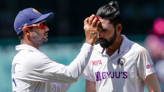 India's Mayank Agarwal, left, rubs the ball on the face of India's Mohammed Siraj during play on day four of the third cricket test between India and Australia at the Sydney Cricket Ground, Sydney, Australia, Sunday, Jan. 10, 2021. (AP)
