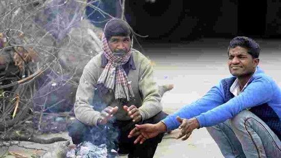 People gather around a bonfire in Noida. (HT Photo) People gather around a bonfire in Noida. (HT Photo)