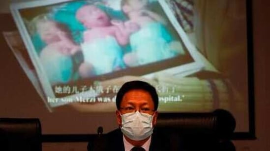 Xu Guixiang, a deputy spokesperson for the Xinjiang regional government, looks up near a slide showing a photo of Uighur infants during a press conference to refute accusations of genocide in Beijing, China. The Chinese official on Monday denied Beijing has imposed coercive birth control measures among Muslim minority women, following an outcry over a tweet by the Chinese Embassy in Washington claiming that government polices had freed women of the Uighur ethnic group from being "baby-making machines." (AP Photo/Ng Han Guan)(AP)