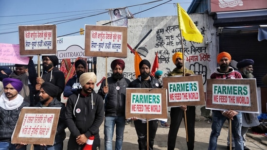 Farmers hold placards at the site during their ongoing protest against new Farm laws at Singhu border, in Delhi on Sunday. (ANI Photo) Farmers hold placards at the site during their ongoing protest against new Farm laws at Singhu border, in Delhi on Sunday. (ANI Photo)