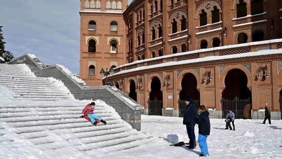 A woman slides down steps outside the Las Ventas bullring in Madrid on January 10. With a sharp drop in temperatures on January 11 and frost freezing much of the snow, which reached more than 50 centimeters in some urban areas, authorities are calling on people to avoid all but essential trips out of their homes.(Gabriel Bouys / AFP)