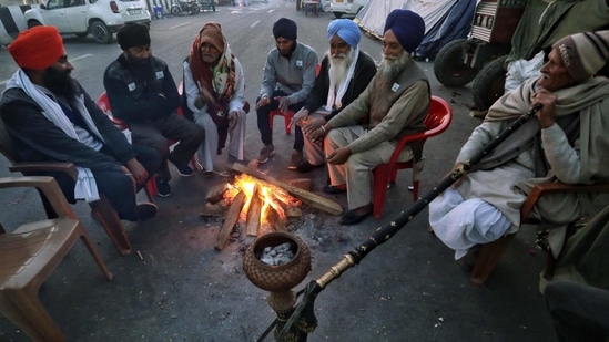 People warm themselves sitting around a bonfire on a cold evening. (ANI) People warm themselves sitting around a bonfire on a cold evening. (ANI)