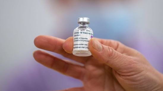 A worker holds a vial of the AstraZeneca Plc and the University of Oxford Covid-19 vaccine.(Bloomberg)