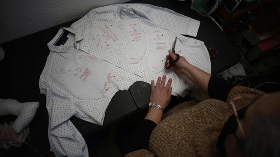 Erendira Guerrero cuts pieces from the shirt of a person who died of Covid-19 as she makes a stuffed bear for one of the deceased's relatives, on January 11. The pandemic has created a new population of distraught customers searching for ways to maintain contact with a loved one taken away suddenly. (Christian Chavez / AP) Erendira Guerrero cuts pieces from the shirt of a person who died of Covid-19 as she makes a stuffed bear for one of the deceased's relatives, on January 11. The pandemic has created a new population of distraught customers searching for ways to maintain contact with a loved one taken away suddenly. (Christian Chavez / AP)