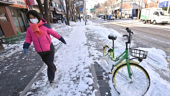 A woman walks along a snow-covered road(AP) A woman walks along a snow-covered road(AP)