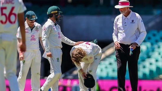 Australia's Will Pucovski reacts after being hurt while fielding during the fifth day of the third cricket Test match between Australia and India at the Sydney Cricket Ground(AFP)