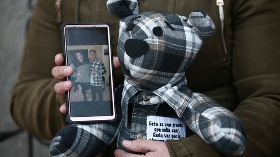 Araceli Ramirez shows a stuffed bear she had made from the shirt of her father, Lorenzo Ramirez, who died so quickly from Covid-19 two months ago that she was unable to say goodbye, as she stands outside the home of bear maker Erendira Guerrero on January 11. (Christian Chavez / AP) Araceli Ramirez shows a stuffed bear she had made from the shirt of her father, Lorenzo Ramirez, who died so quickly from Covid-19 two months ago that she was unable to say goodbye, as she stands outside the home of bear maker Erendira Guerrero on January 11. (Christian Chavez / AP)
