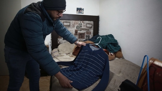 Jaime Walfre Aguilar Martinez, whose 50-year-old father died of Covid-19 in November, selects one of his father's favorite sweaters to have a stuffed bear made from the fabric, at his home in Ciudad Juarez on January 11. (Christian Chavez / AP) Jaime Walfre Aguilar Martinez, whose 50-year-old father died of Covid-19 in November, selects one of his father's favorite sweaters to have a stuffed bear made from the fabric, at his home in Ciudad Juarez on January 11. (Christian Chavez / AP)
