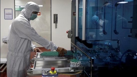 An employee in personal protective equipment handling vials of Covishield at Serum Institute of India, in Pune. (REUTERS) An employee in personal protective equipment handling vials of Covishield at Serum Institute of India, in Pune. (REUTERS)