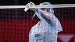 A Badminton Association of Thailand official wearing a face mask and shield while cleaning the net as a preventive measure against the spread of the Covid-19 coronavirus(AFP) A Badminton Association of Thailand official wearing a face mask and shield while cleaning the net as a preventive measure against the spread of the Covid-19 coronavirus(AFP)