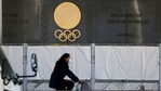A woman wearing a face mask to protect against the spread of the coronavirus rides a bicycle along the Japan National Stadium, where opening ceremony and many other events are planned for Tokyo 2020 Olympics, as engravings in honor of 1964 Tokyo Olympics are seen on the side of the stadium wall behind the fence Wednesday, Jan. 13, 2021, in Tokyo. (AP Photo/Kiichiro Sato)(AP) A woman wearing a face mask to protect against the spread of the coronavirus rides a bicycle along the Japan National Stadium, where opening ceremony and many other events are planned for Tokyo 2020 Olympics, as engravings in honor of 1964 Tokyo Olympics are seen on the side of the stadium wall behind the fence Wednesday, Jan. 13, 2021, in Tokyo. (AP Photo/Kiichiro Sato)(AP)