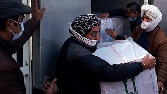 Workers carry the first consignment of Covid-19 vaccine at cold storage in Jammu on Wednesday.(ANI Photo)