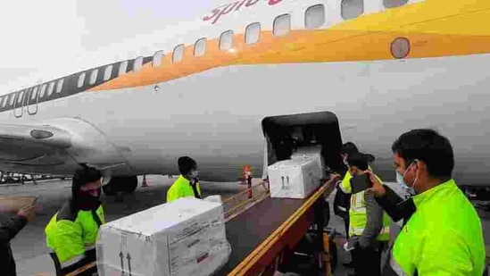 The first consignment of Covishield arrives at Indira Gandhi International (IGI) Airport in a special SpiceJet flight from Pune, in New Delhi on January 12. Flights from Pune transported the vaccine, developed by Oxford University and AstraZeneca, and is marketed in India as Covishield, to Delhi, Chennai, Kolkata, Guwahati, Shillong, Ahmedabad, Hyderabad, Vijayawada, Bhubaneswar, Patna, Bengaluru, Lucknow and Chandigarh, while three trucks left for Mumbai in the evening, HT reported.(HT Photo) The first consignment of Covishield arrives at Indira Gandhi International (IGI) Airport in a special SpiceJet flight from Pune, in New Delhi on January 12. Flights from Pune transported the vaccine, developed by Oxford University and AstraZeneca, and is marketed in India as Covishield, to Delhi, Chennai, Kolkata, Guwahati, Shillong, Ahmedabad, Hyderabad, Vijayawada, Bhubaneswar, Patna, Bengaluru, Lucknow and Chandigarh, while three trucks left for Mumbai in the evening, HT reported.(HT Photo)