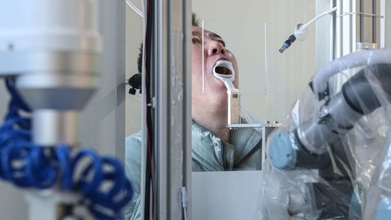 A robot machine takes a swab sample from a man to test for Covid-19 infection in Shenyang, Liaoning province on January 13. The total number of confirmed Covid-19 cases in mainland China now stands at 87,706, while the death toll remained unchanged at 4,634, Reuters reported.(AFP)
