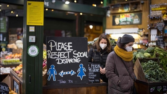 Customers wear face masks because of the coronavirus pandemic as they shop at Borough Market in London on January 12. (AFP)